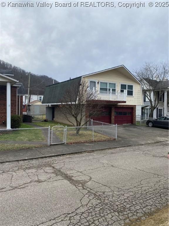 510 S Railway St, Cedar Grove, WV 25039 - view of front of home featuring asphalt driveway, a garage, a fenced front yard, and a gate