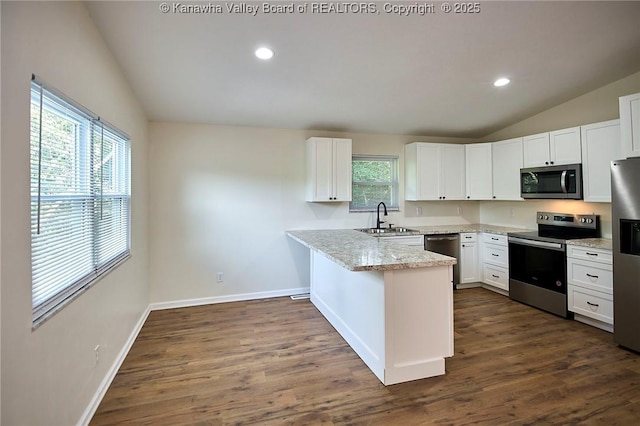 4013 Seymour Ln, Charleston, WV 25313 - kitchen with stainless steel appliances, lofted ceiling, a peninsula, white cabinetry, and dark wood-style flooring