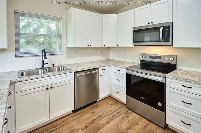 4013 Seymour Ln, Charleston, WV 25313 - kitchen with stainless steel appliances, white cabinets, light countertops, and light wood finished floors
