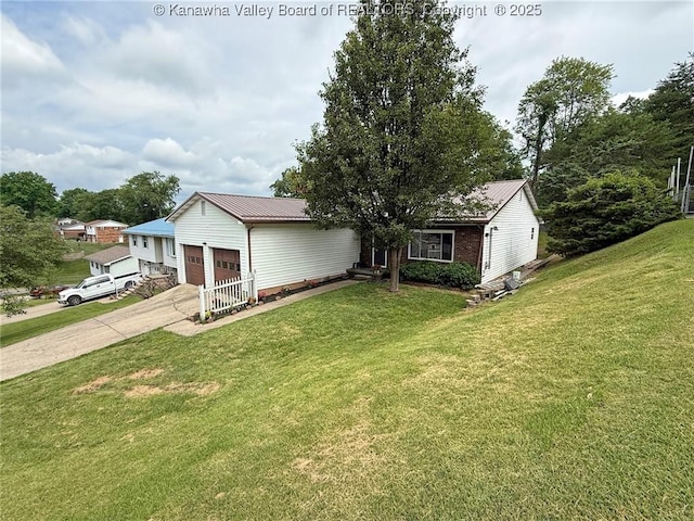 5005 Buffy Dr, Cross Lanes, WV 25313 - view of front of house with concrete driveway, a front yard, an attached garage, and a metal roof