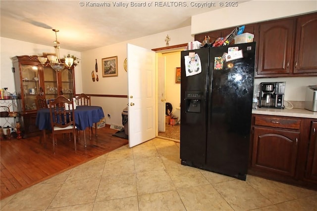 5005 Buffy Dr, Cross Lanes, WV 25313 - kitchen featuring black fridge with ice dispenser, a chandelier, light countertops, light tile patterned floors, and pendant lighting