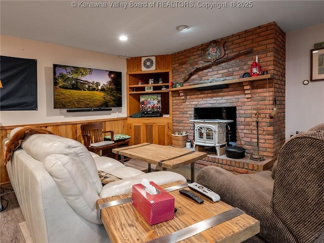 114 Shady Ln, Winfield, WV 25213 - living room with wood finished floors, a wood stove, built in features, and a wainscoted wall