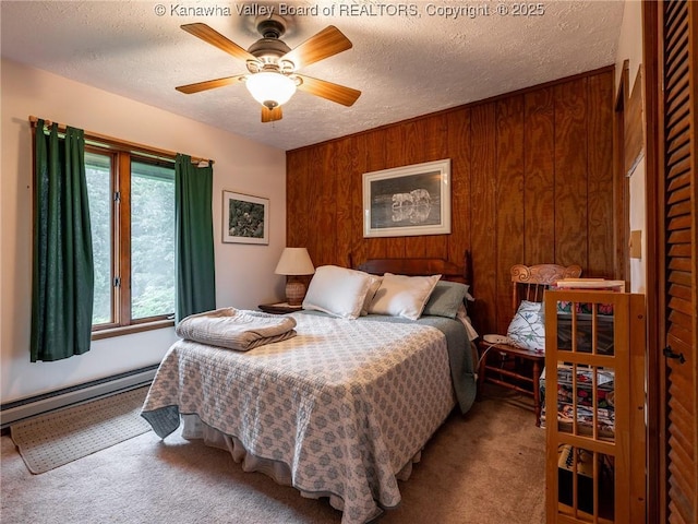 114 Shady Ln, Winfield, WV 25213 - carpeted bedroom with a baseboard heating unit, wood walls, a textured ceiling, and ceiling fan