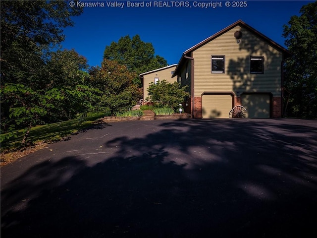 114 Shady Ln, Winfield, WV 25213 - view of side of property with a garage, driveway, and brick siding