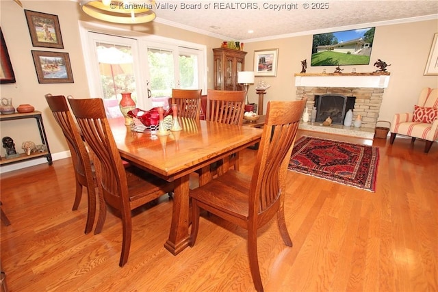 1500 Longridge Rd, Charleston, WV 25314 - dining space with light wood-style flooring, a stone fireplace, and crown molding