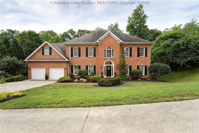 135 E Ridge Rd, Charleston, WV 25314 - colonial house featuring concrete driveway, brick siding, a front yard, and a garage