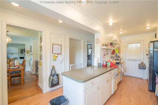 1324 Kanawha Ave, Dunbar, WV 25064 - kitchen with white cabinetry, light wood-type flooring, ornamental molding, freestanding refrigerator, and dark countertops