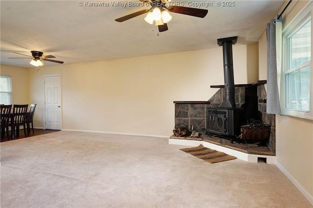 55 Corky Dr, Poca, WV 25159 - unfurnished living room with ceiling fan, a wood stove, and carpet floors