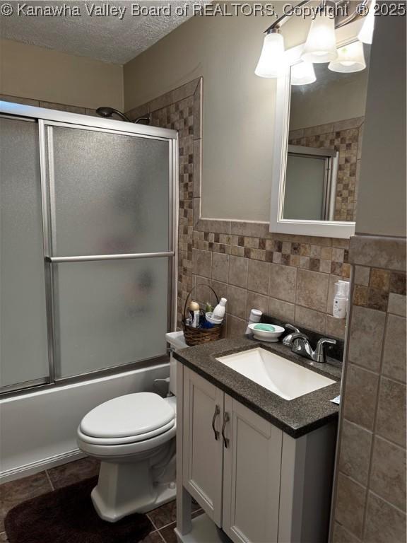 1198 Caney Branch Rd, Chapmanville, WV 25508 - full bathroom with tile walls, vanity, shower / bath combination with glass door, tile patterned floors, and a textured ceiling