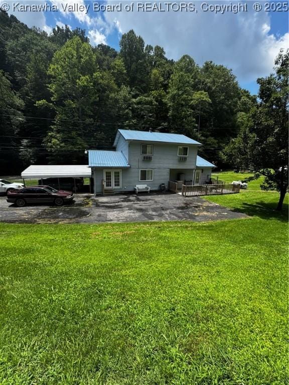 1198 Caney Branch Rd, Chapmanville, WV 25508 - back of property featuring a lawn, a view of trees, a metal roof, and a patio area