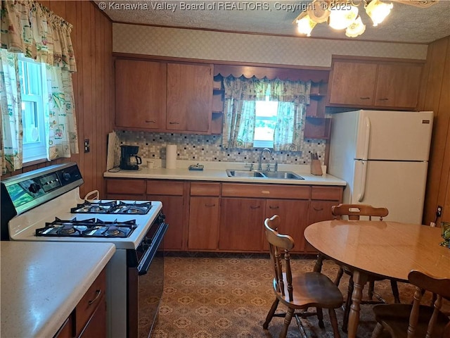 588 Saunders Creek Rd, Milton, WV 25541 - kitchen with gas stove, freestanding refrigerator, brown cabinetry, and light countertops