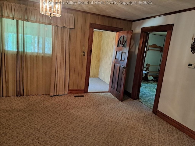 588 Saunders Creek Rd, Milton, WV 25541 - unfurnished room with carpet flooring, a chandelier, wooden walls, and crown molding