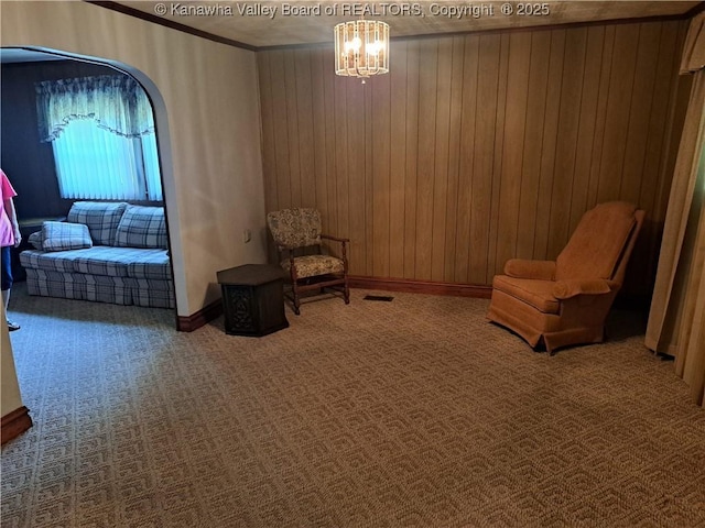 588 Saunders Creek Rd, Milton, WV 25541 - sitting room featuring carpet flooring, wood walls, a chandelier, crown molding, and arched walkways
