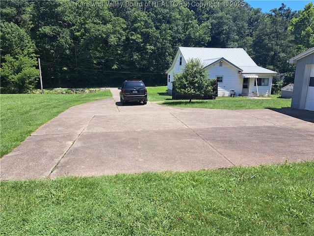 588 Saunders Creek Rd, Milton, WV 25541 - view of side of property featuring a lawn, driveway, and a metal roof