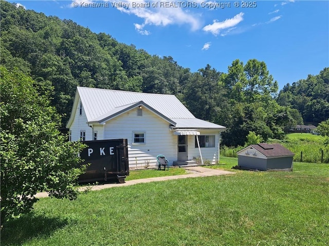 588 Saunders Creek Rd, Milton, WV 25541 - rear view of property with a lawn, a metal roof, and a wooded view