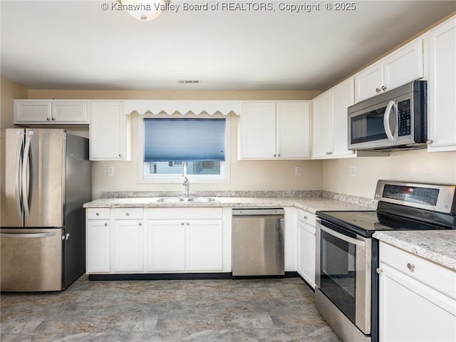 309 Kentucky Ave, Saint Albans, WV 25177 - kitchen with appliances with stainless steel finishes, white cabinets, and light stone counters