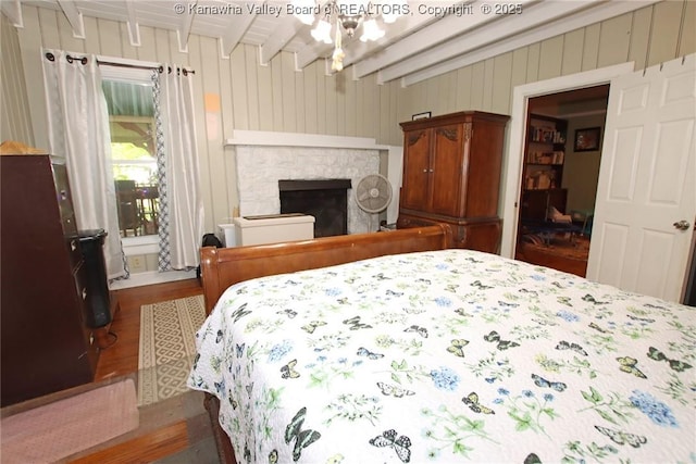 4261 Washington St W, Dunbar, WV 25313 - bedroom featuring beam ceiling, wood finished floors, a fireplace, and wooden walls