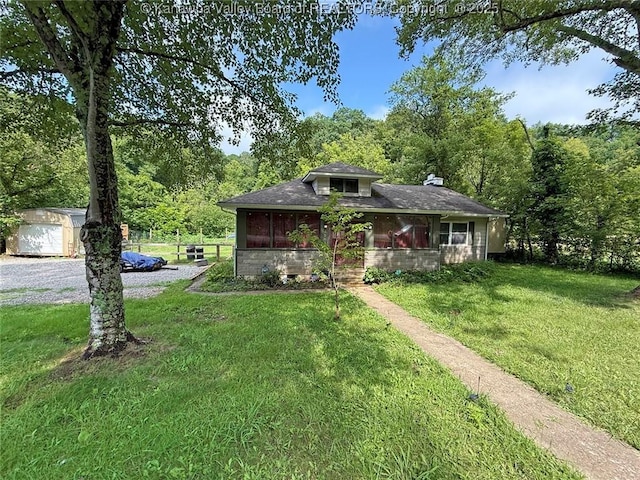 4261 Washington St W, Dunbar, WV 25313 - bungalow-style house featuring a front yard, a wooded view, an outdoor structure, and a detached garage