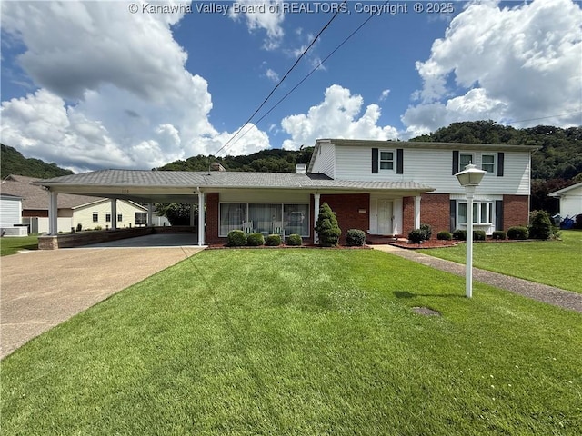 105 Sayer Cir, Logan, WV 25601 - traditional-style house featuring an attached carport, brick siding, concrete driveway, and a front lawn