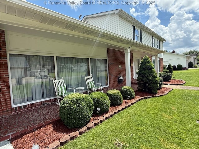105 Sayer Cir, Logan, WV 25601 - view of front of house featuring brick siding, a front lawn, and covered porch