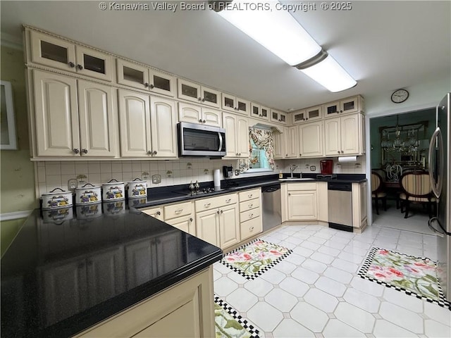 105 Sayer Cir, Logan, WV 25601 - kitchen featuring appliances with stainless steel finishes, glass insert cabinets, dark countertops, and decorative backsplash