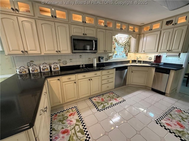 105 Sayer Cir, Logan, WV 25601 - kitchen with stainless steel appliances, decorative backsplash, glass insert cabinets, dark countertops, and cream cabinets
