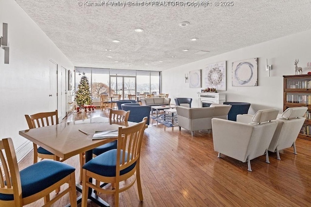 1800 Roundhill Rd Unit 205/206, Charleston, WV 25304 - dining area featuring a textured ceiling, wood-type flooring, recessed lighting, a fireplace, and a wall of windows