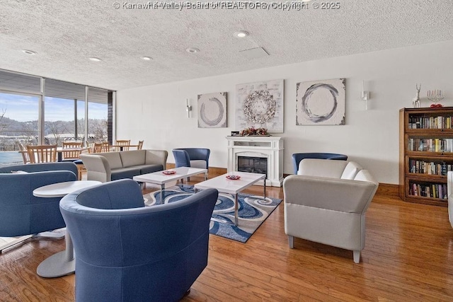 1800 Roundhill Rd Unit 205/206, Charleston, WV 25304 - living area with a textured ceiling, wood finished floors, a glass covered fireplace, and floor to ceiling windows