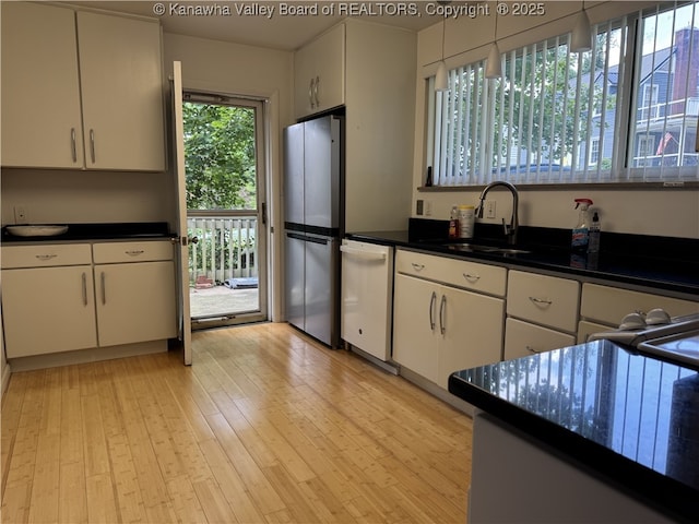 119 Swarthmore Ave, Charleston, WV 25302 - kitchen with freestanding refrigerator, white dishwasher, dark countertops, light wood finished floors, and white cabinets