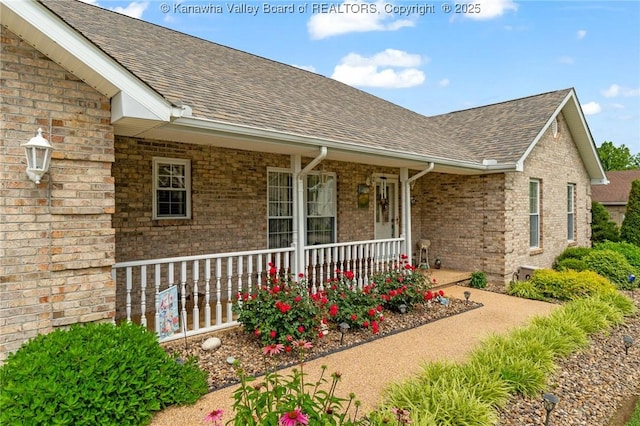 182 Summer Dr, Culloden, WV 25510 - view of exterior entry featuring a porch, roof with shingles, and brick siding