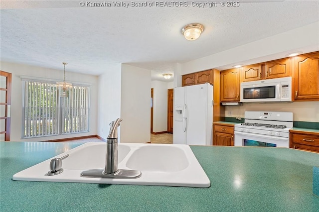 182 Summer Dr, Culloden, WV 25510 - kitchen featuring white appliances, brown cabinetry, a chandelier, hanging light fixtures, and a textured ceiling