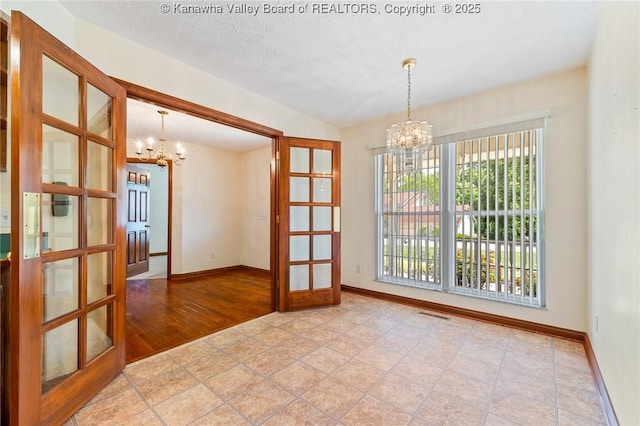 182 Summer Dr, Culloden, WV 25510 - empty room featuring a chandelier and french doors