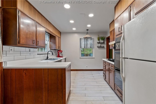 51 Roland Park Dr, Huntington, WV 25705 - kitchen featuring freestanding refrigerator, light countertops, recessed lighting, a peninsula, and decorative backsplash
