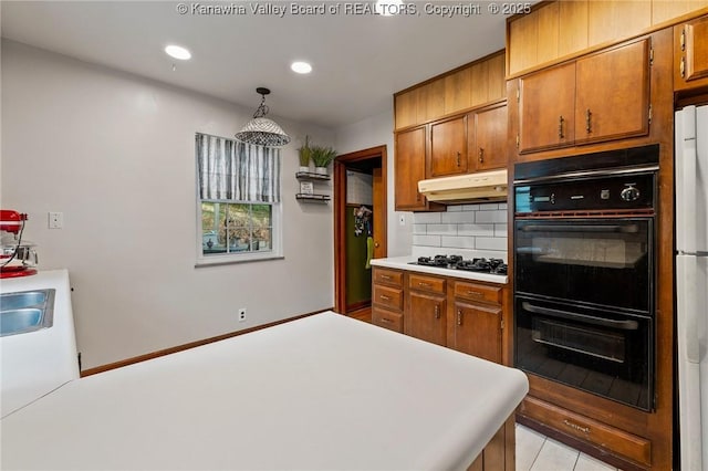 51 Roland Park Dr, Huntington, WV 25705 - kitchen with under cabinet range hood, gas stovetop, brown cabinets, tasteful backsplash, and light countertops