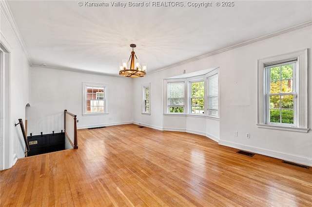 887 Poplar Rd, Charleston, WV 25302 - empty room featuring light wood-style flooring, plenty of natural light, a chandelier, and ornamental molding