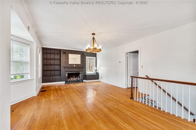 887 Poplar Rd, Charleston, WV 25302 - unfurnished living room with a chandelier, ornamental molding, light wood-type flooring, and a high end fireplace