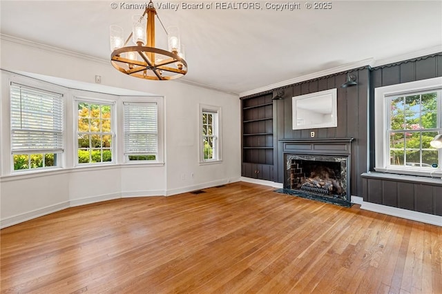 887 Poplar Rd, Charleston, WV 25302 - unfurnished living room featuring a chandelier, light wood-type flooring, ornamental molding, built in features, and a fireplace