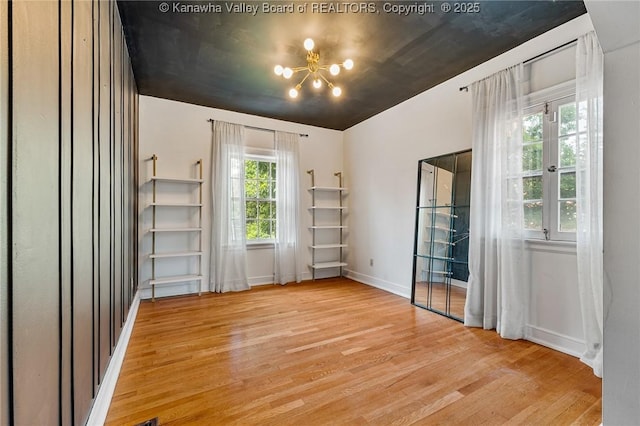 887 Poplar Rd, Charleston, WV 25302 - unfurnished room with light wood-type flooring and a chandelier