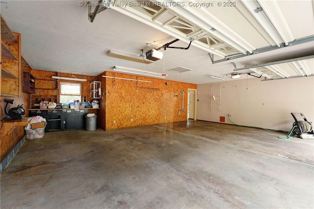 5126 Big Tyler Rd, Cross Lanes, WV 25313 - garage featuring a workshop area, a garage door opener, and wooden walls