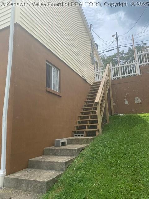 5126 Big Tyler Rd, Cross Lanes, WV 25313 - view of side of home with stairs, stucco siding, and a yard
