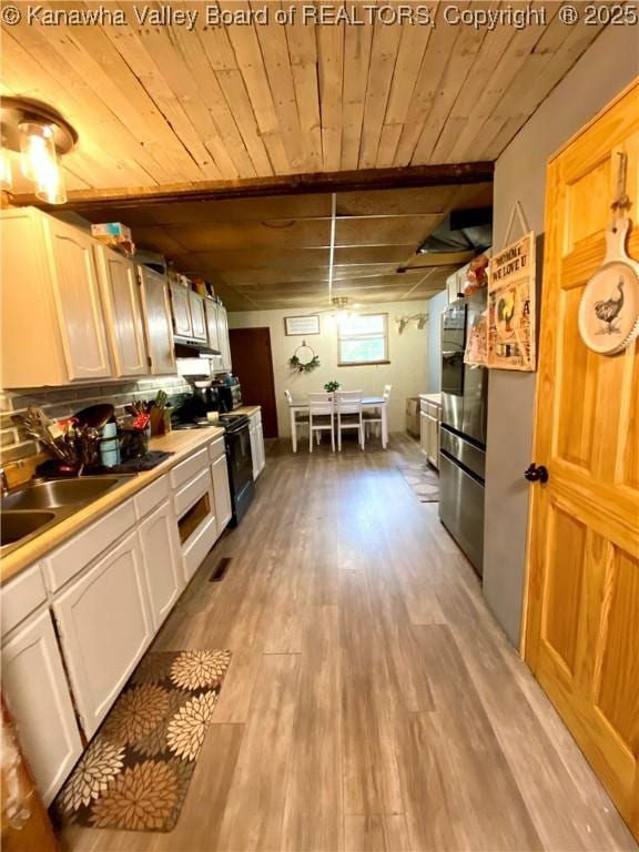 1091/2 Hillcrest Dr, Ripley, WV 25271 - kitchen with light wood finished floors, white cabinetry, light countertops, under cabinet range hood, and wooden ceiling