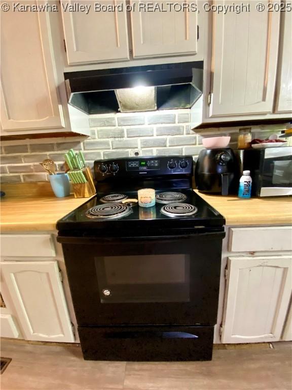 1091/2 Hillcrest Dr, Ripley, WV 25271 - kitchen featuring black range with electric stovetop, ventilation hood, decorative backsplash, and white cabinetry