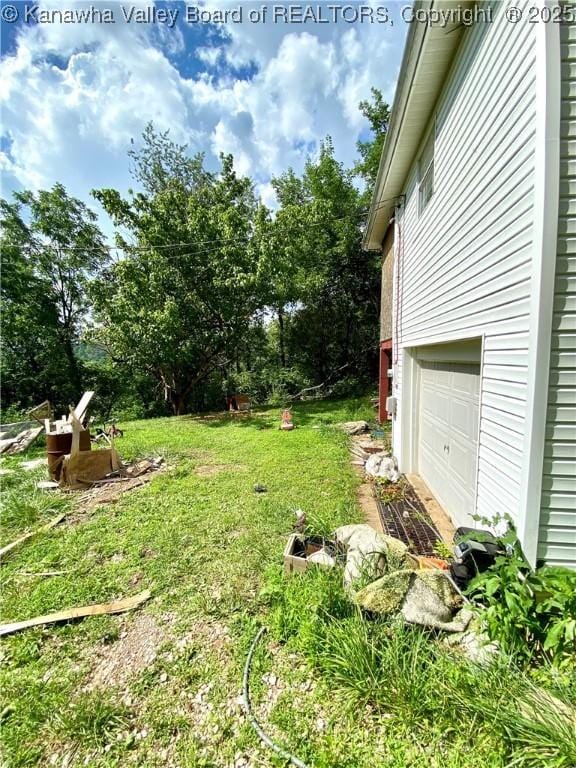 1091/2 Hillcrest Dr, Ripley, WV 25271 - view of green lawn with an attached garage and view of wooded area