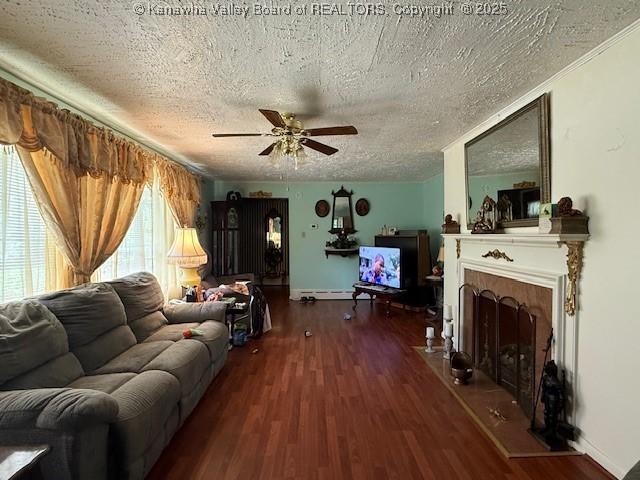 1022 Riverside Dr, Welch, WV 24801 - living room with ceiling fan, wood finished floors, a textured ceiling, a fireplace, and a baseboard heating unit