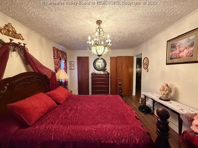 1022 Riverside Dr, Welch, WV 24801 - bedroom with wood finished floors, a chandelier, and a textured ceiling