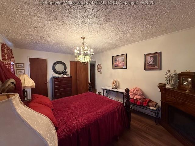 1022 Riverside Dr, Welch, WV 24801 - bedroom with a textured ceiling, dark wood-type flooring, and a chandelier