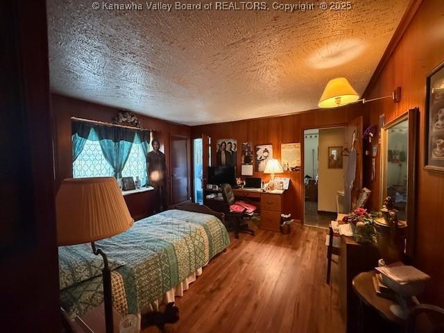 1022 Riverside Dr, Welch, WV 24801 - bedroom featuring a textured ceiling, wood finished floors, wooden walls, and an office area