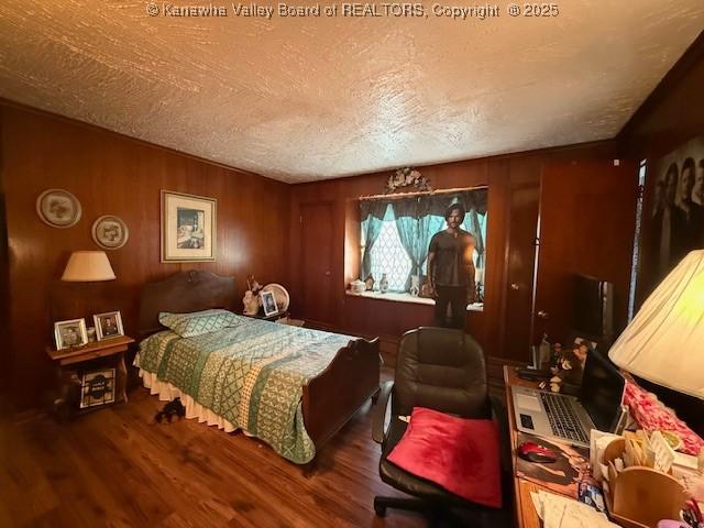 1022 Riverside Dr, Welch, WV 24801 - bedroom with wood finished floors, a textured ceiling, and wood walls