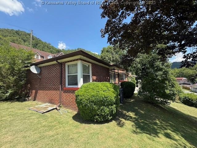 1022 Riverside Dr, Welch, WV 24801 - view of home's exterior featuring brick siding and a yard
