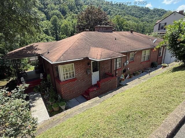 1022 Riverside Dr, Welch, WV 24801 - view of front of property featuring a front lawn, brick siding, and a shingled roof
